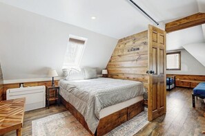 Una camera da letto con un letto di legno, una finestra, un termosifone e un pavimento in legno.