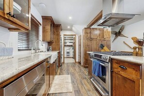 A kitchen with wooden cabinets, stainless steel appliances, and a central island.