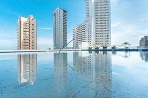 A swimming pool with clear reflections of surrounding high-rise buildings.