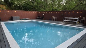 A rectangular swimming pool with a wooden deck surrounding it. - Secluded Retreat with Pool, King Beds in a Historic District, 2 mi from Oaklawn! (Hot Springs)