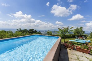 Ein Pool mit Blick auf die Stadt und das dahinterliegende Gebirge.