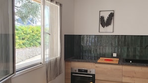 Uma cozinha moderna com janela, lava-louças, pia e arte decorativa na parede.