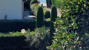 A coastal property with a well-maintained garden, a large tree, and a view of the sea. - Betulla Holiday Apartment (Lazise)