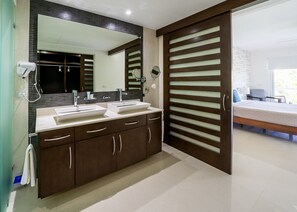 A modern bathroom with a double sink vanity, a large mirror, and a walk-in shower.