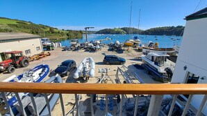 Un puerto deportivo con barcos amarrados, un coche y un edificio al fondo.