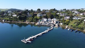 Un pueblo costero con un puerto deportivo, casas y zonas verdes.