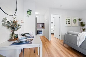 Un espace de vie moderne comprenant un coin repas, une cuisine et un canapé.