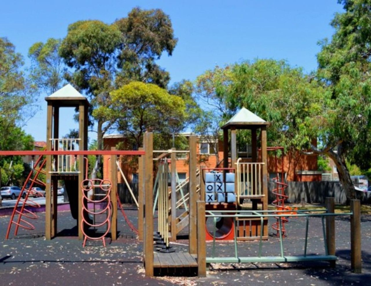 A playground with various play structures including a slide, swings, and climbing frames.
