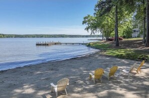 Une propriété au bord du lac, dotée d’un quai s’avançant dans l’eau, entourée d’arbres et offrant un espace de détente extérieur.