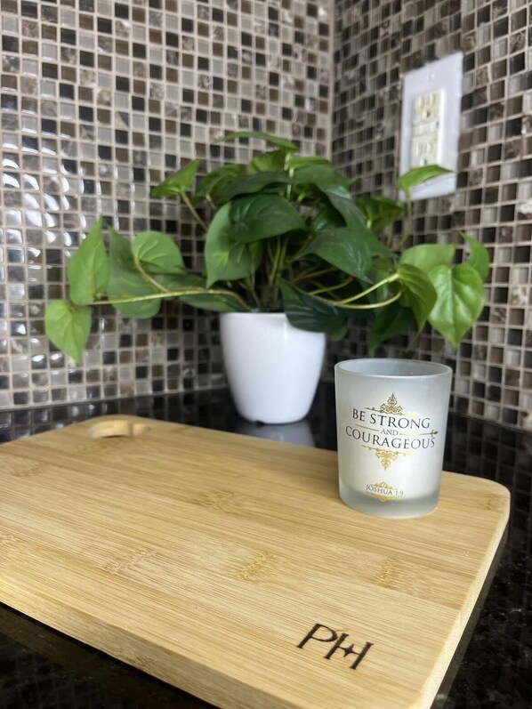 A candle with the text "BE STRONG AND COURAGEOUS" on a wooden tray. - Stay in a cozy downtown cottage within 5 mi of I-95, Hwy 301 & NC Hwy 87!  (Fayetteville)