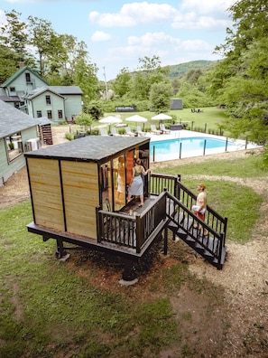 A wooden cabin with a deck and stairs leading to a pool area. - The Bend: Stony Clove Suite • Pool • Sauna • Creek (Phoenicia)