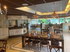 Enjoy meals in this dining area with a variety of seating options and a central counter offering coffee and services.