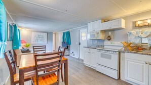 A compact kitchen with white cabinets, a microwave, an oven, and a sink. - 5 Mi to Golf: Charming Hernando Home w/ Deck (Hernando)