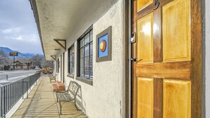 A building with a wooden door, a bench, and a window with a sun decoration.