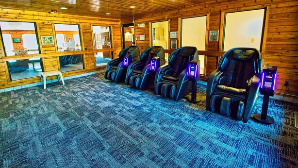 A room with massage chairs, a small desk, and wooden walls. - One queen bed, private bathroom with jetted tub, mini fridge, and single-serve coffee maker. (Boulder Junction)