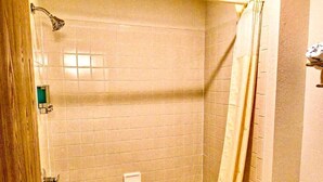 A bathroom with a bathtub, toilet, and shower curtain. - One queen bed, private bathroom with jetted tub, mini fridge, and single-serve coffee maker. (Boulder Junction)