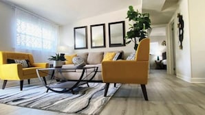 Una sala de estar moderna con un sofá, sillones y una mesa de centro.