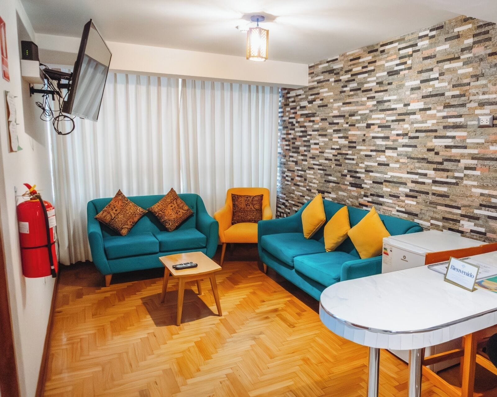 A modern living room with two sofas, a coffee table, and a small white table with a welcome sign.