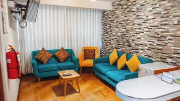 A modern living room with two sofas, a coffee table, and a small white table with a welcome sign.
