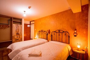 Ein Hotelzimmer mit zwei Betten, einem Holzschrank und einem Spiegel.