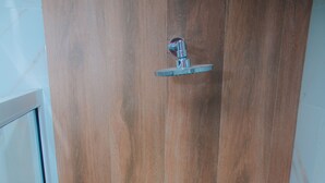 A wooden door with a glass shower enclosure. - FABIS HOTEL (Baños de Agua Santa)