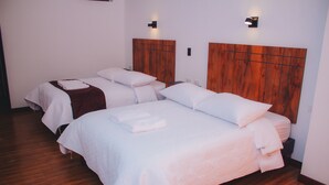 A hotel room with two beds, wooden headboards, and wall-mounted lighting. - FABIS HOTEL (Baños de Agua Santa)