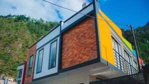 A multi-story hotel with a brick facade and large windows. - FABIS HOTEL (Baños de Agua Santa)