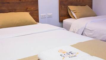 A hotel room with two beds, each with white bedding and beige pillows. There is a logo for FABIS Hotel on the left side of the image.