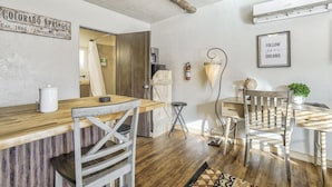 A rustic kitchen with a wooden countertop, a coffee maker, and a sign reading "COLORADO SPRINGS Est. 1886 Elevation 6035 ft."
