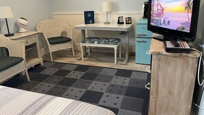 A hotel room with a bed, a desk, a chair, a television, and a minibar. - Captain Quarter's Studio near Bishop's Beach - Pet friendly Studio (Homer)