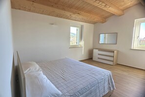 Un dormitorio con cama, cómoda y ventana.