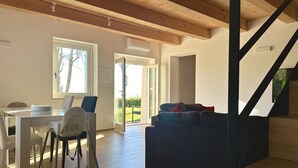 Un intérieur moderne comprenant un coin repas, un canapé et un escalier.