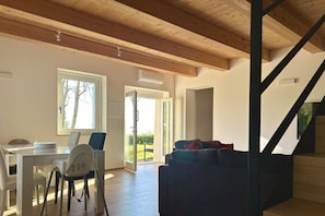Un intérieur moderne comprenant un coin repas, un canapé et un escalier.