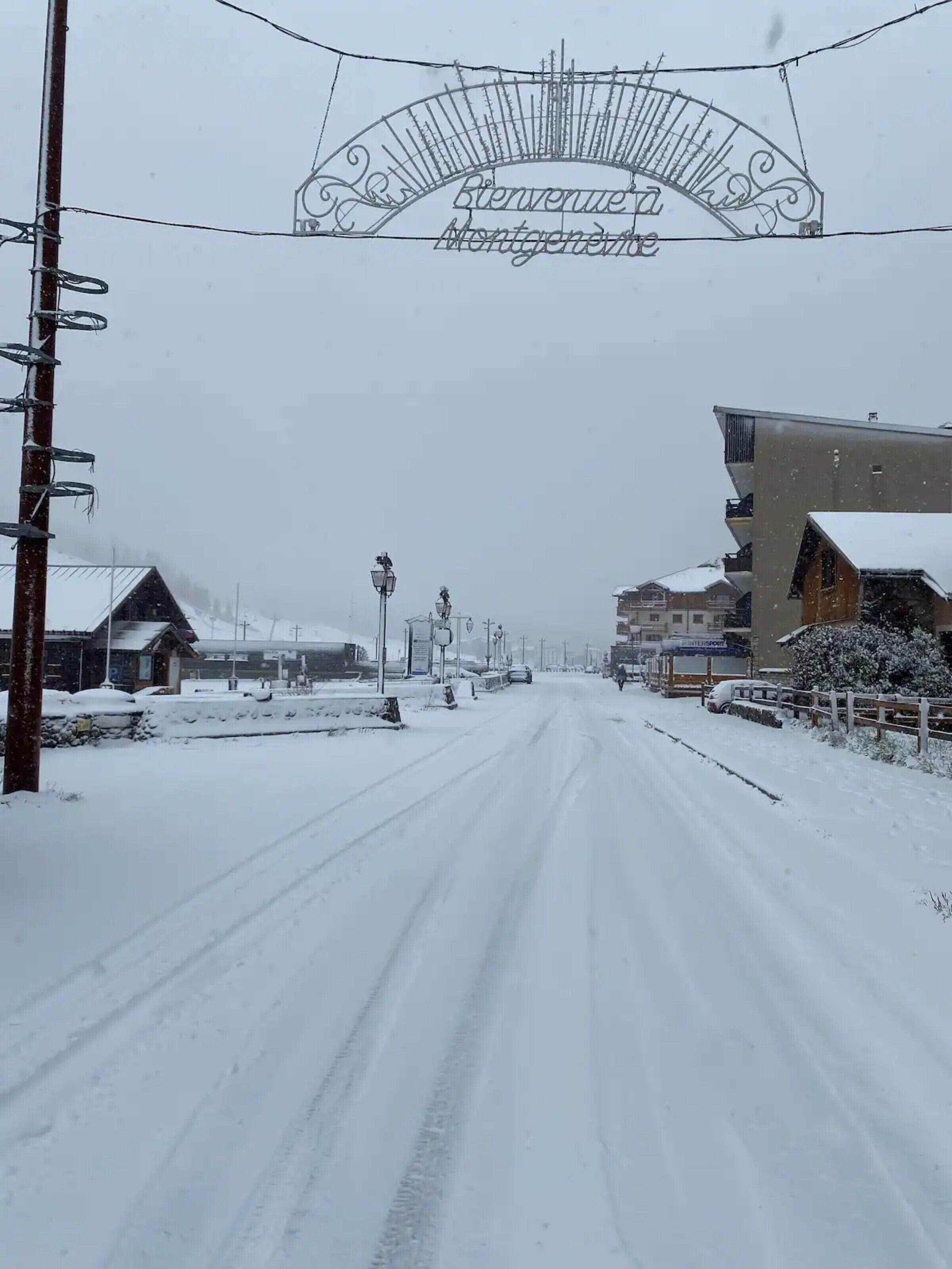 Carretera nevada con un cartel que dice 'Bienvenue Montgenois'.