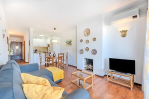 Sala de estar com sofá, televisão e arte decorativa na parede.