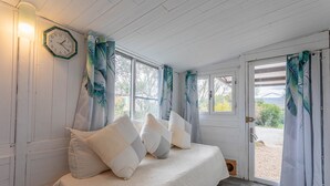 Een slaapkamer met een bed, een klok en gordijnen.