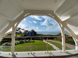 Un espace extérieur abrité, offrant une vue sur la mer et un paysage verdoyant.