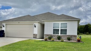A single-story house with a garage and a covered porch area. - Like New Home close to town family friendly, quiet and close to amenities.  (Conway)