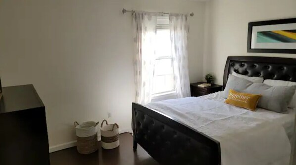 A bedroom with a bed, a nightstand, a lamp, and a window with curtains. - Fully furnished home, sleeps 8 (Terry)