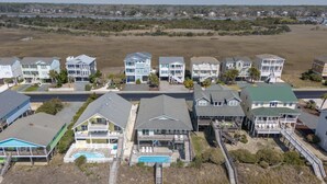 Zona residencial costera con casas que tienen balcones y una piscina.