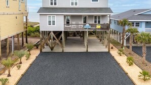 A two-story building with a balcony, wooden deck, and a sign indicating 'Southern Comfort.' - Hobbs Realty - Enjoy "Southern Comfort" at it's best in this gorgeous oceanfront home! (Holden Beach)