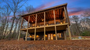 A wooden cabin with a balcony, surrounded by trees. - JULY DISCOUNT! New Modern Luxury Cabin- Hot Tub, Game Room, Fire Pit (Blue Ridge)