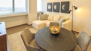 A modern living room with a round table, two chairs, a sofa, and a floor lamp. - Tribu Coordenada Lafayette (Guadalajara)