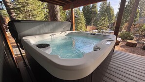 A hot tub on a wooden deck with a view of trees. - Spacious, newly remodeled, perfect location w/BBQ, Hot Tub, pool table, SmartTV (Carnelian Bay)