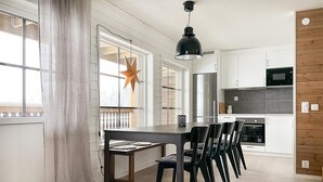 Una cocina moderna con armarios blancos, una mesa de comedor negra y sillas.