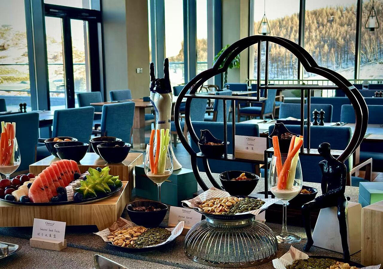 A buffet setup with various food items and a decorative sculpture.