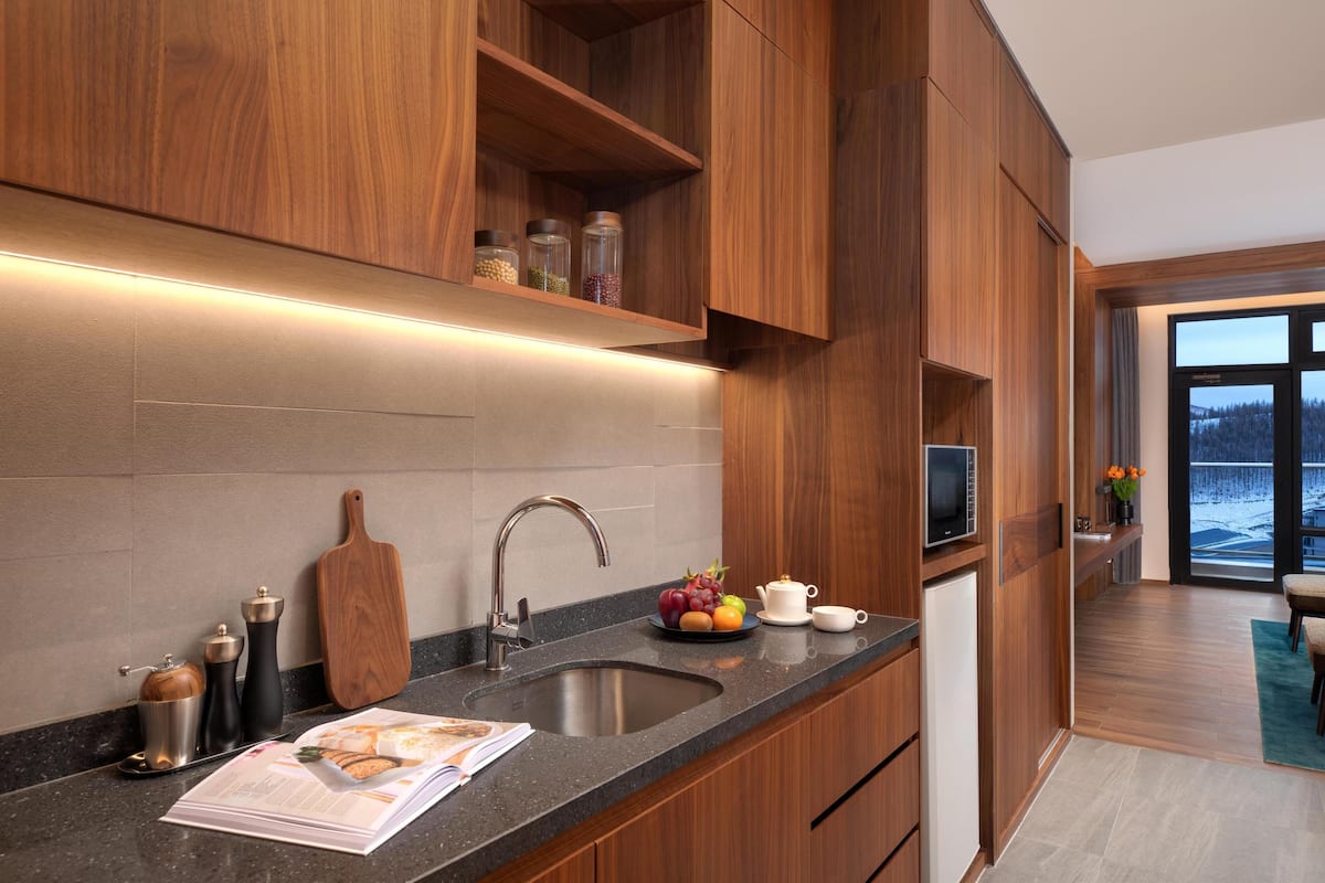A modern kitchen with wooden cabinets, a granite countertop, and a built-in oven.