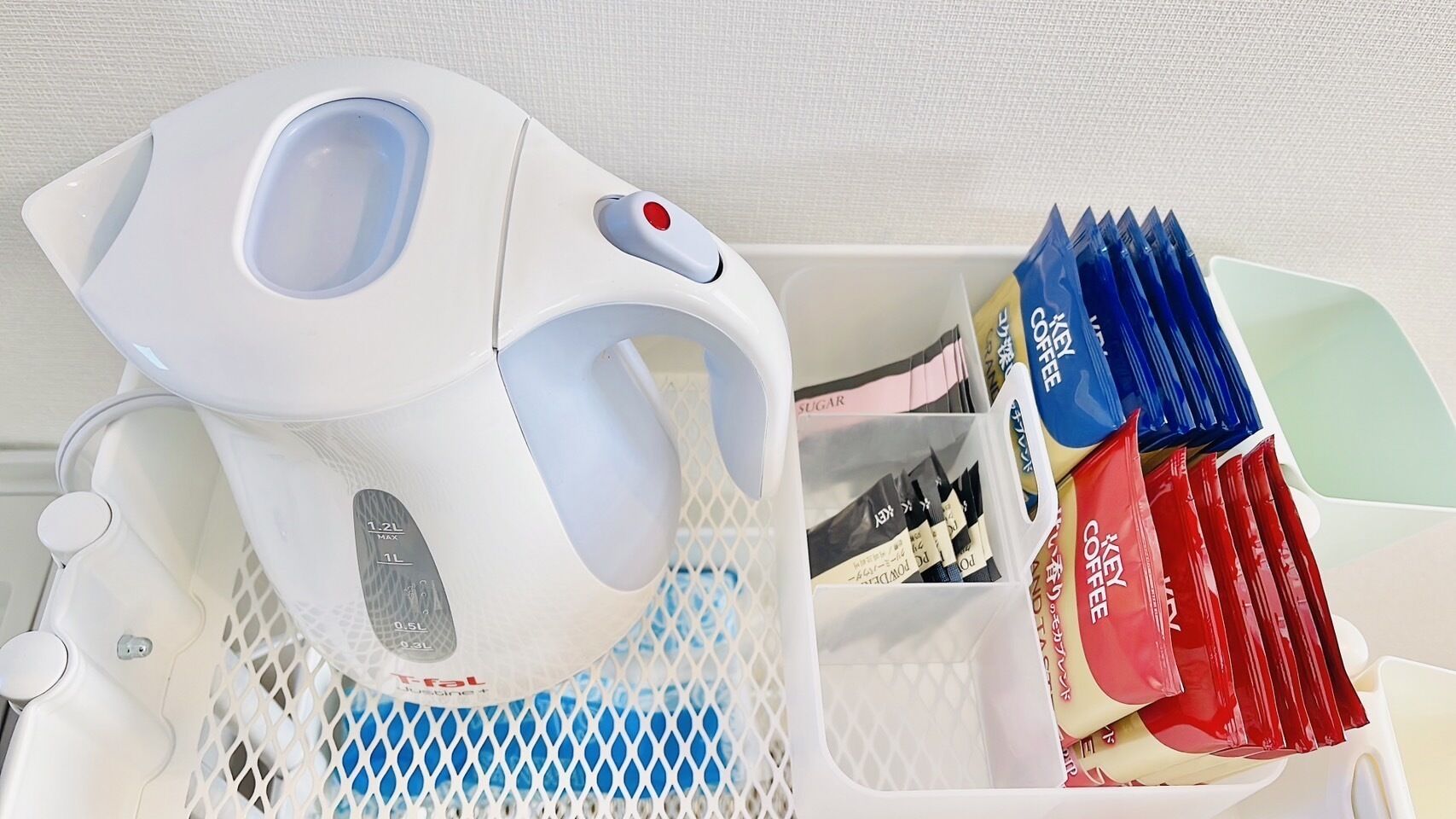 A coffee machine with a water reservoir and a basket containing coffee pods.