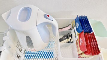 A coffee machine with a water reservoir and a basket containing coffee pods.