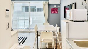 A modern kitchen with a dining area, white appliances, and a large window with curtains. - Megu Fuji Plus+ (Fujiyoshida)
